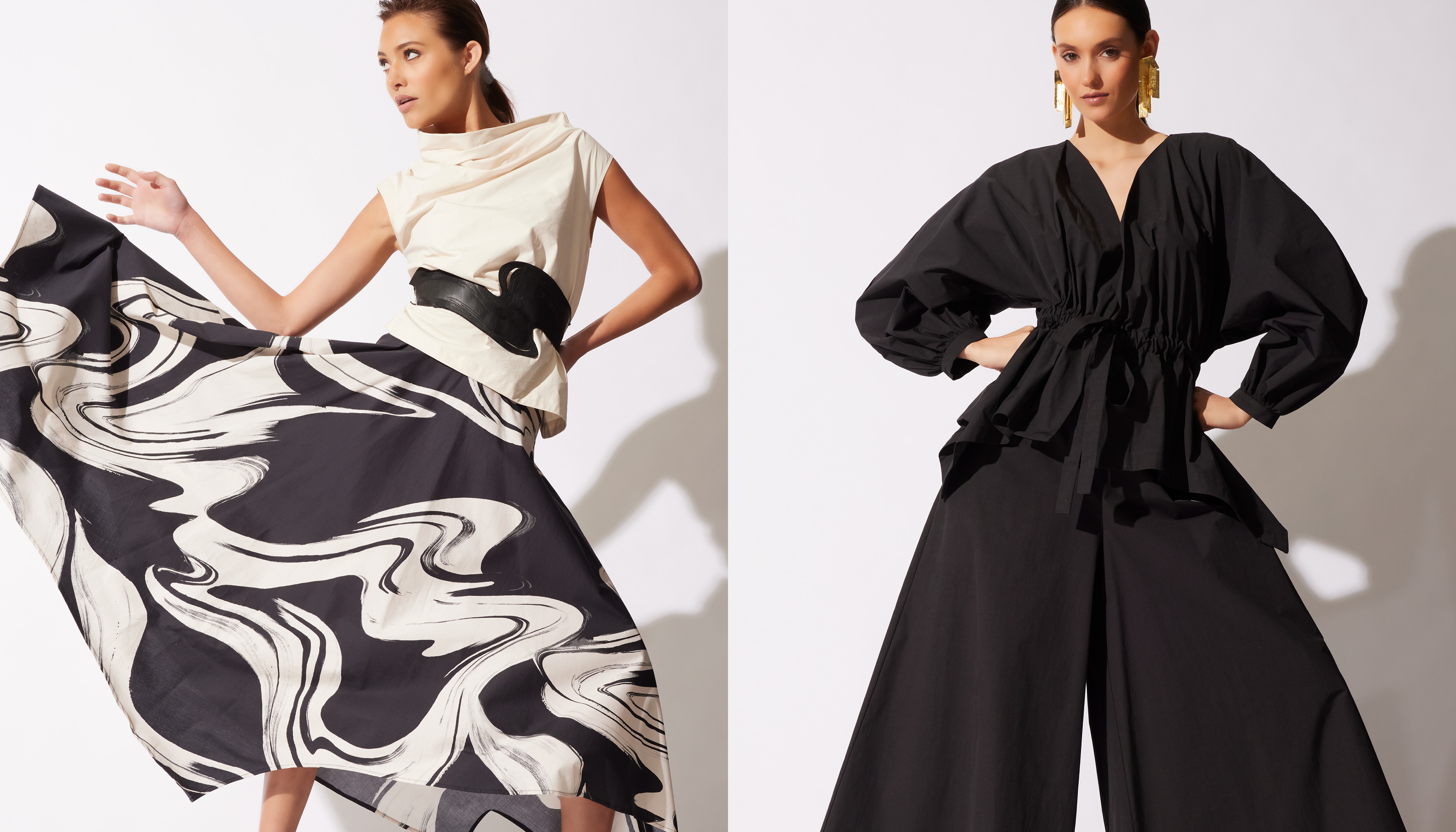 Two women modeling different flowing black and white outfits; one draped, one structured