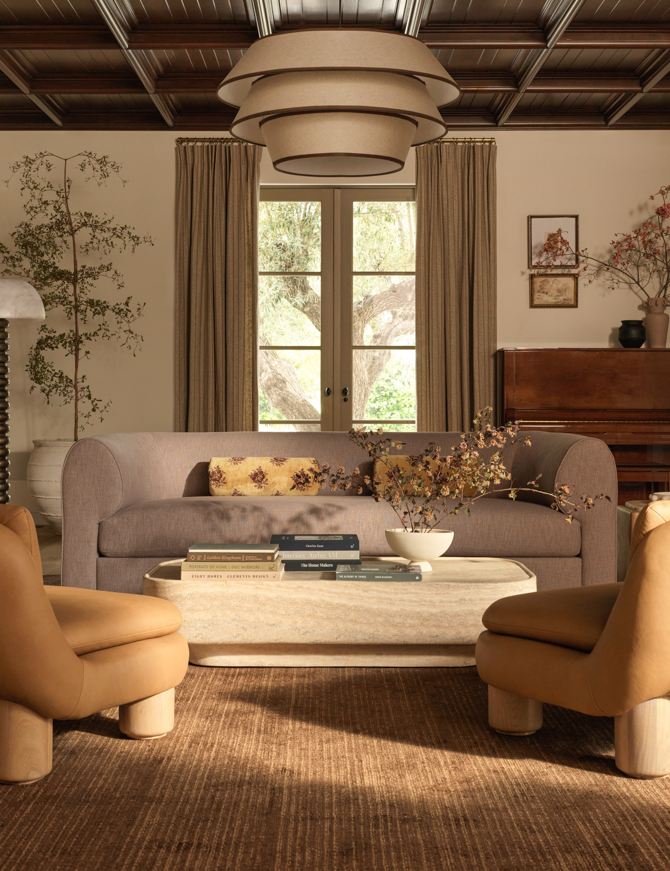Cozy living room with beige sofa, two chairs, and large window with natural light