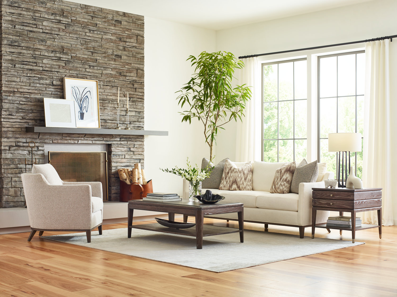 Modern living room with sofa, chairs, coffee table, and stone fireplace