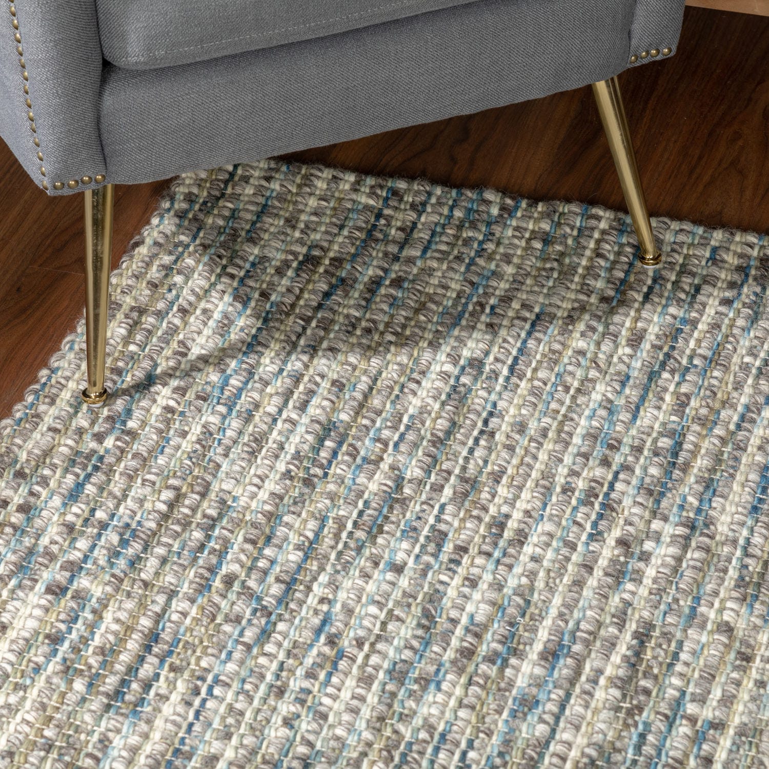 Multicolored woven rug under a gray chair leg