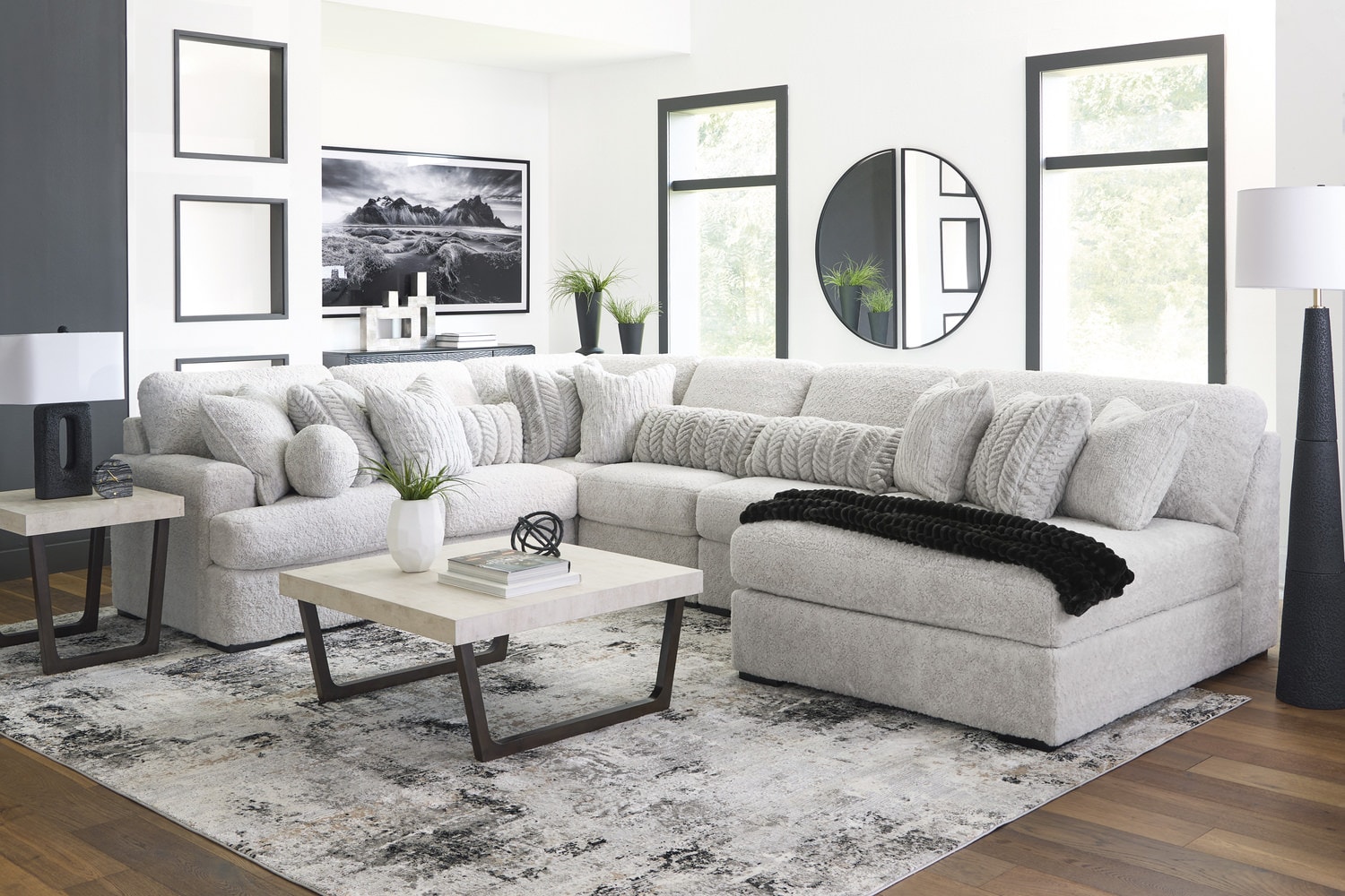 Modern living room with a sectional sofa, coffee table, and styled wall art