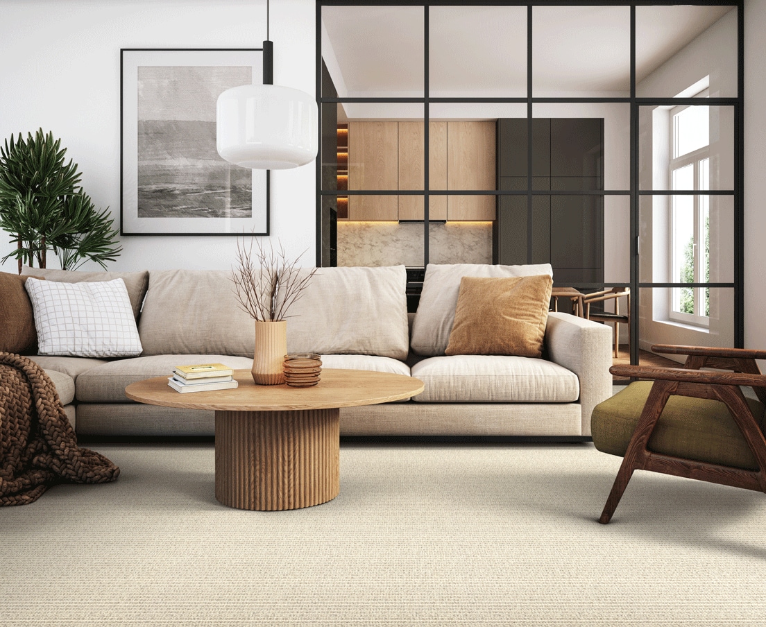 Modern living room with beige sofa, wooden furniture, and large windows