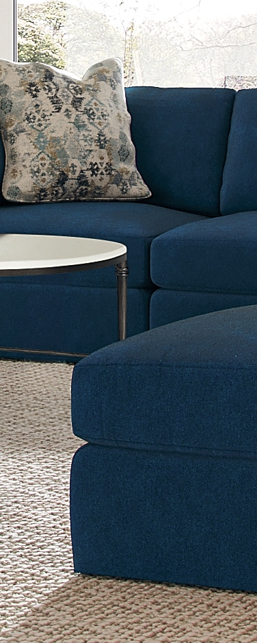 Blue sectional sofa with floral pillow and round white table