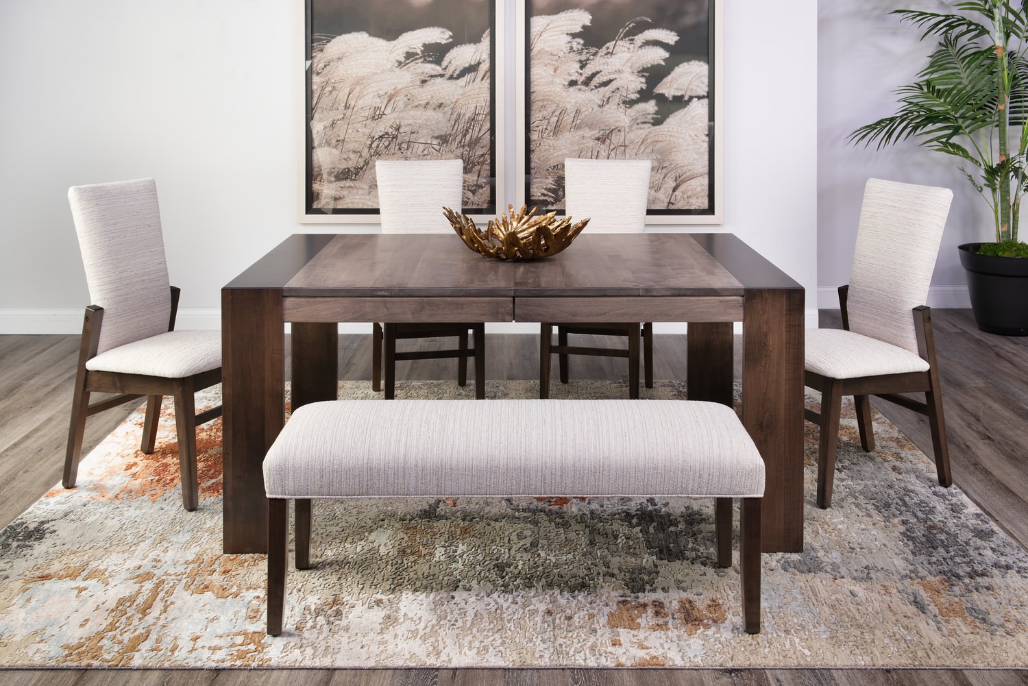 Modern dining room with a wooden table, bench, four chairs, rug, and wall art