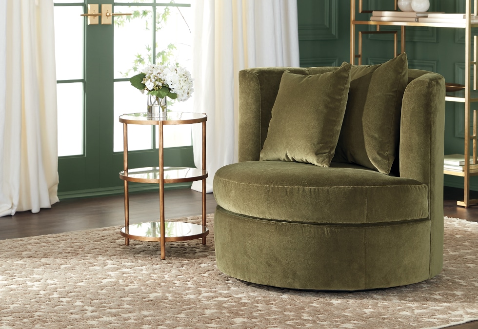 Green velvet armchair in a stylish room with white curtains and a green door