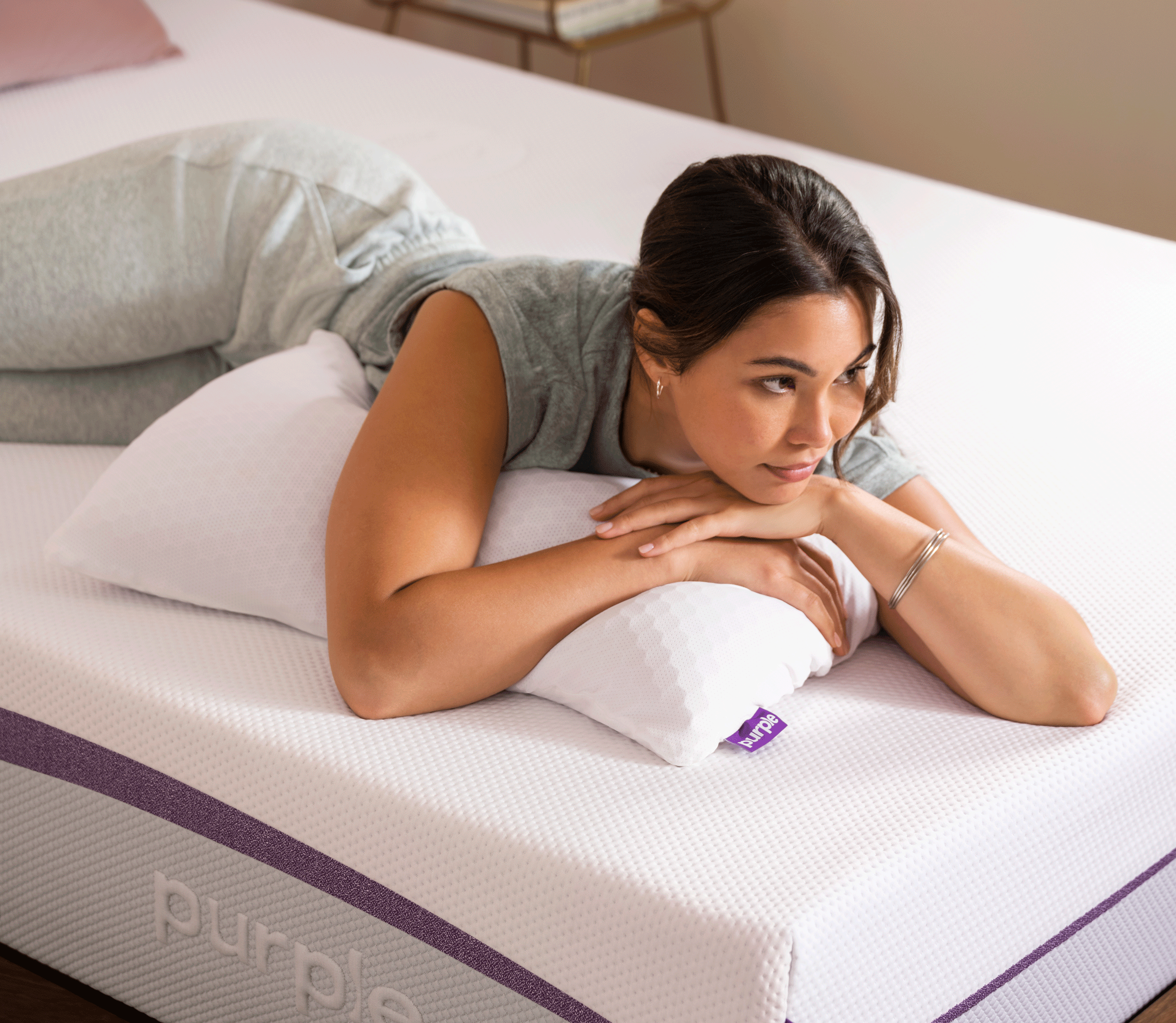 Woman resting on a Purple mattress in a bright bedroom