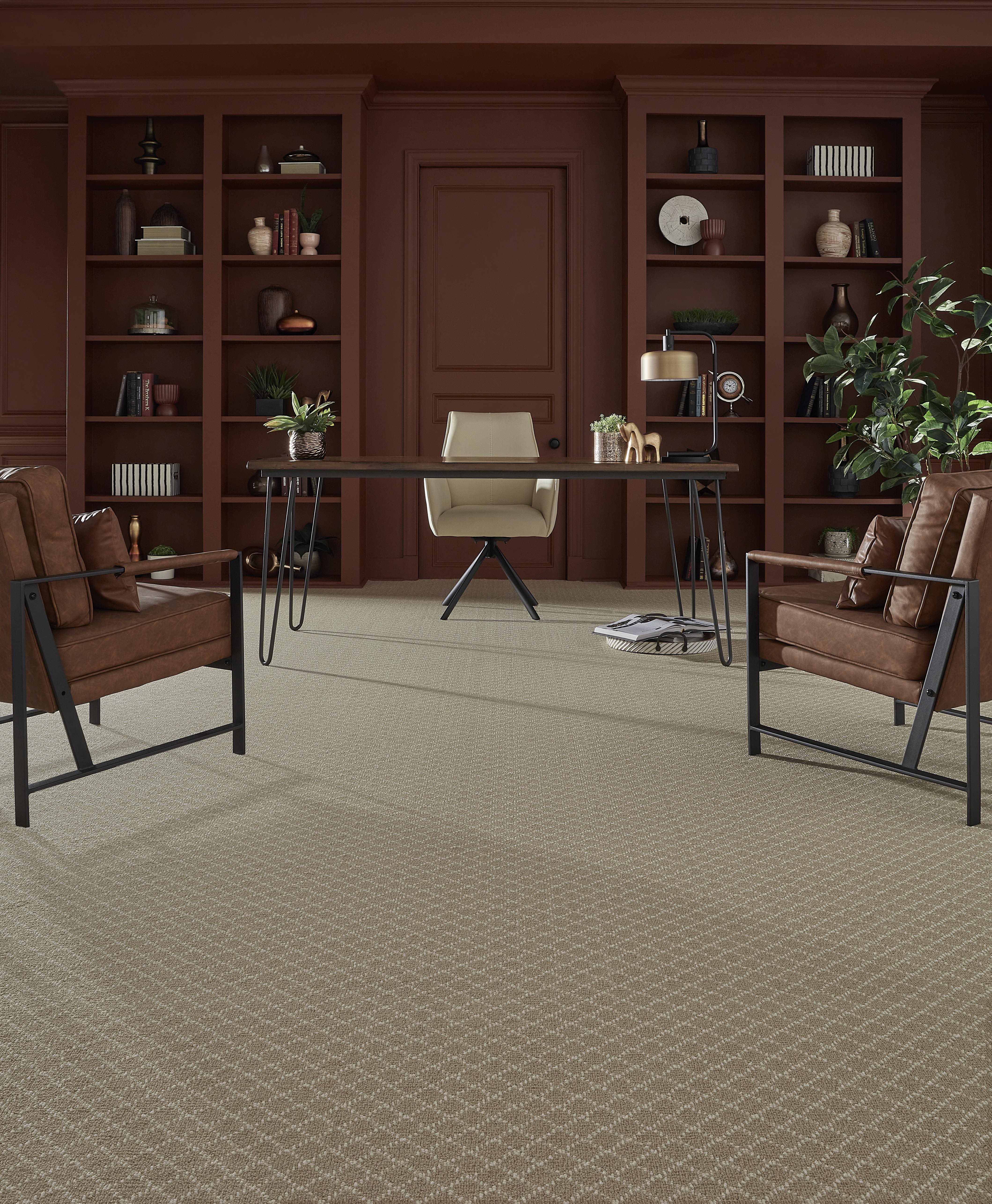 Elegant home office with a desk, two leather chairs, and bookshelves full of plants and books
