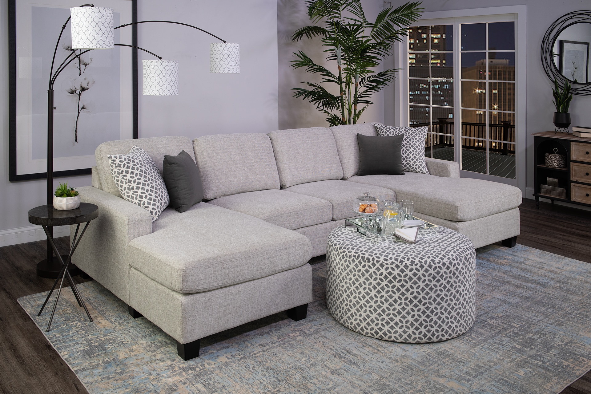 Elegant living room with a sectional sofa, stylish rug, and decorative plants