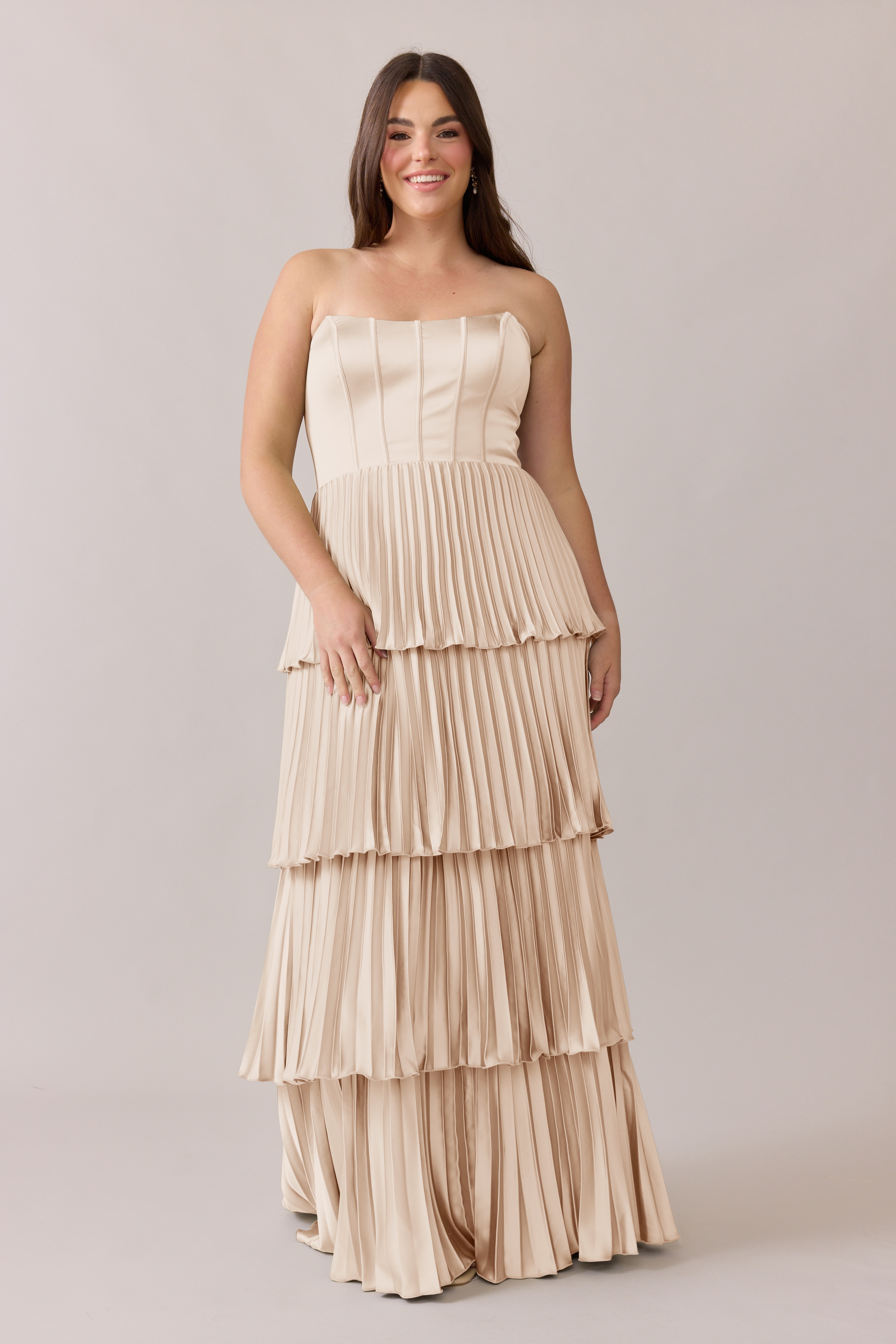 Woman smiling in a tiered cream strapless dress