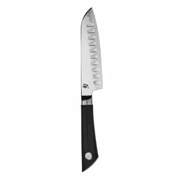 A santoku knife with a black handle and scalloped blade