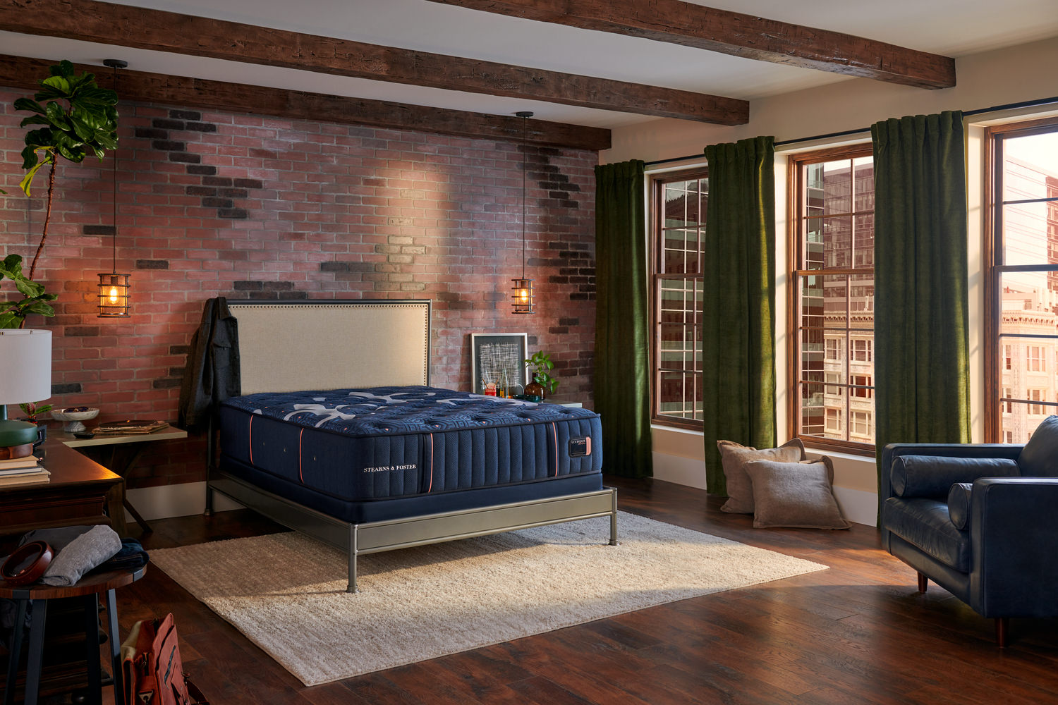 Stylish bedroom with brick walls, green drapes, and a blue bed