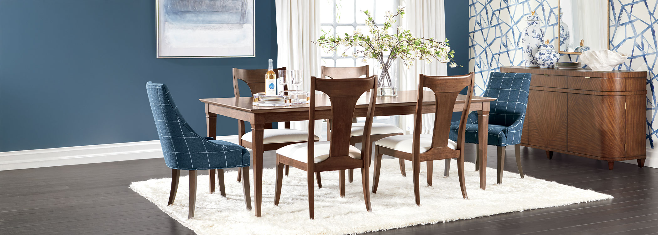 Modern dining room with a wooden table, six blue chairs, and a white rug