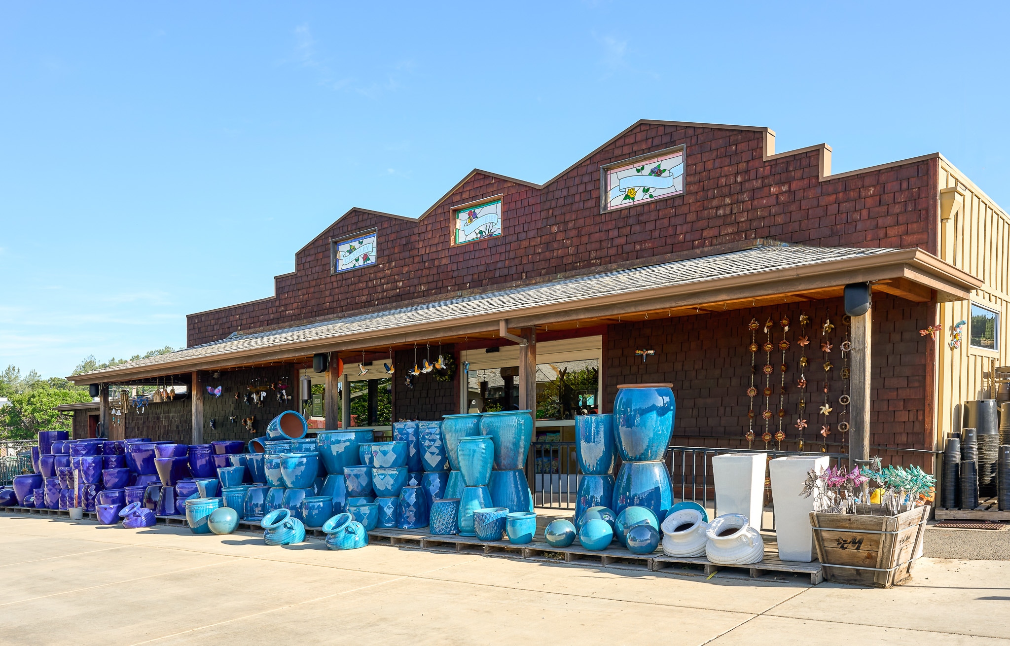 Exterior of a CVS Pharmacy with blue pots and home goods displayed outside under a clear sky