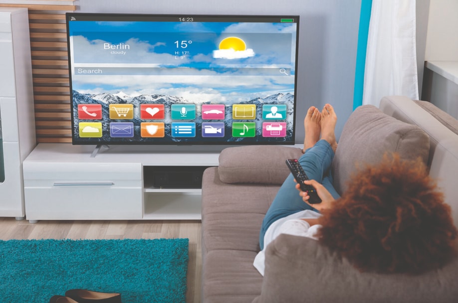 Personne se relaxant sur un canapé utilisant une smart TV