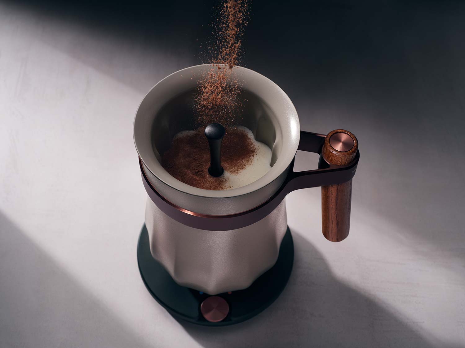 Cocoa powder being sifted into a metal French press on a shadowed surface
