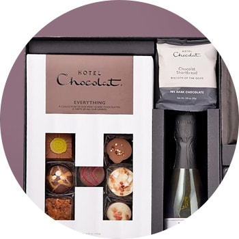 Circle-cropped image of a Hotel Chocolat gift set with assorted chocolates and a bottle