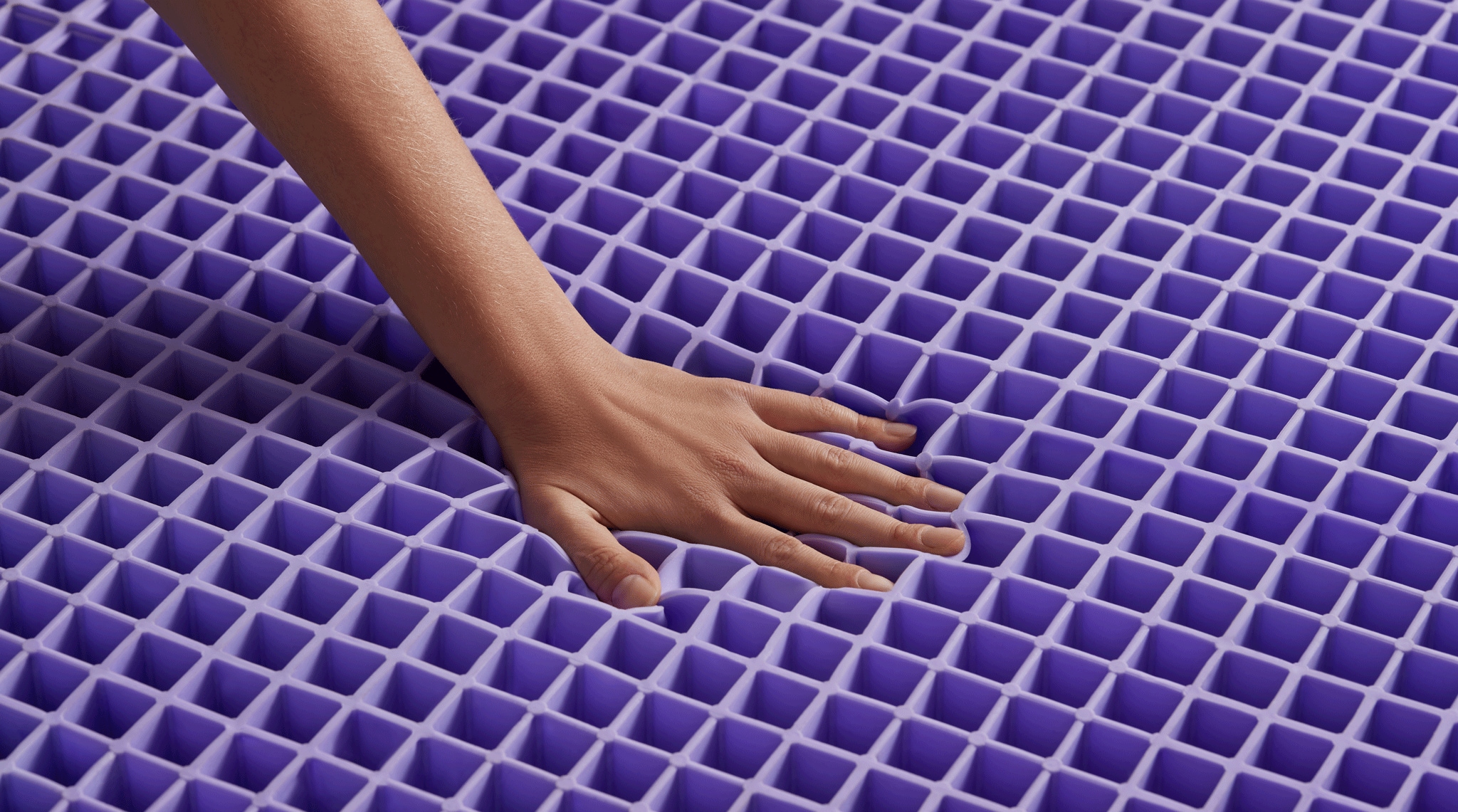 Human hand resting on a textured purple surface