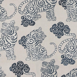 Patterned fabric featuring stylized blue tigers and cloud motifs on a beige background