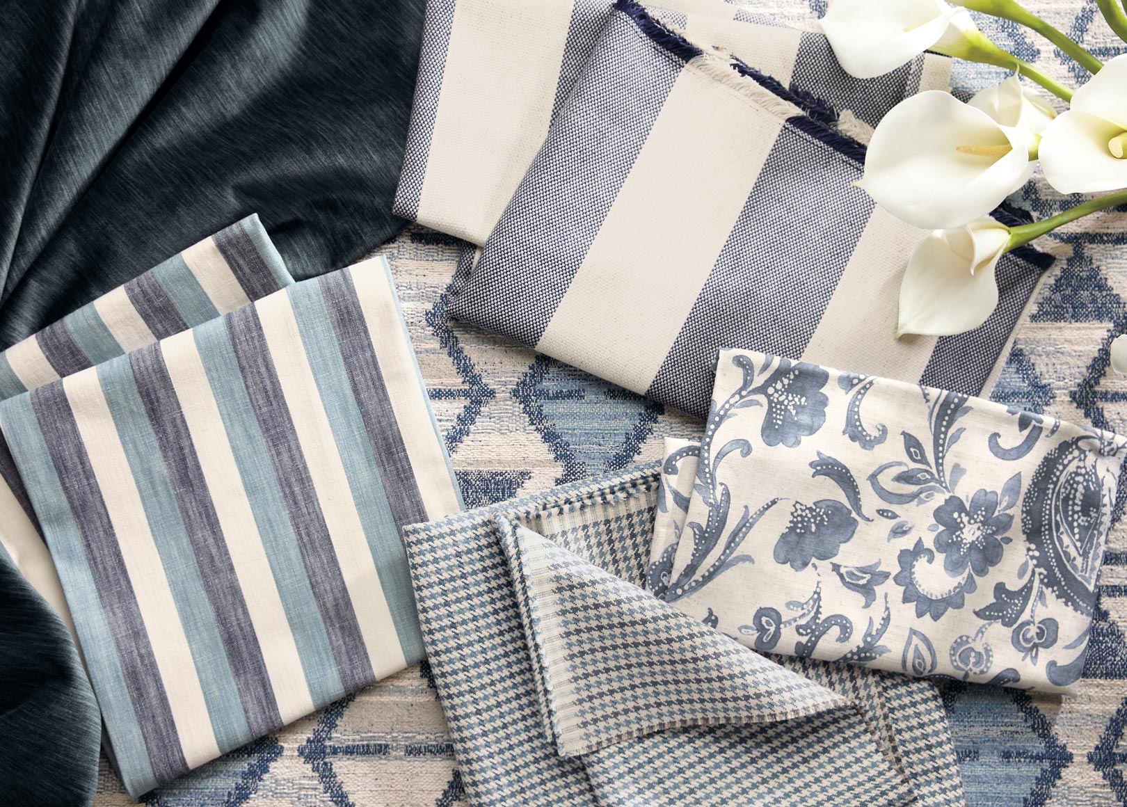 Assorted fabric swatches in various patterns and colors displayed on a table