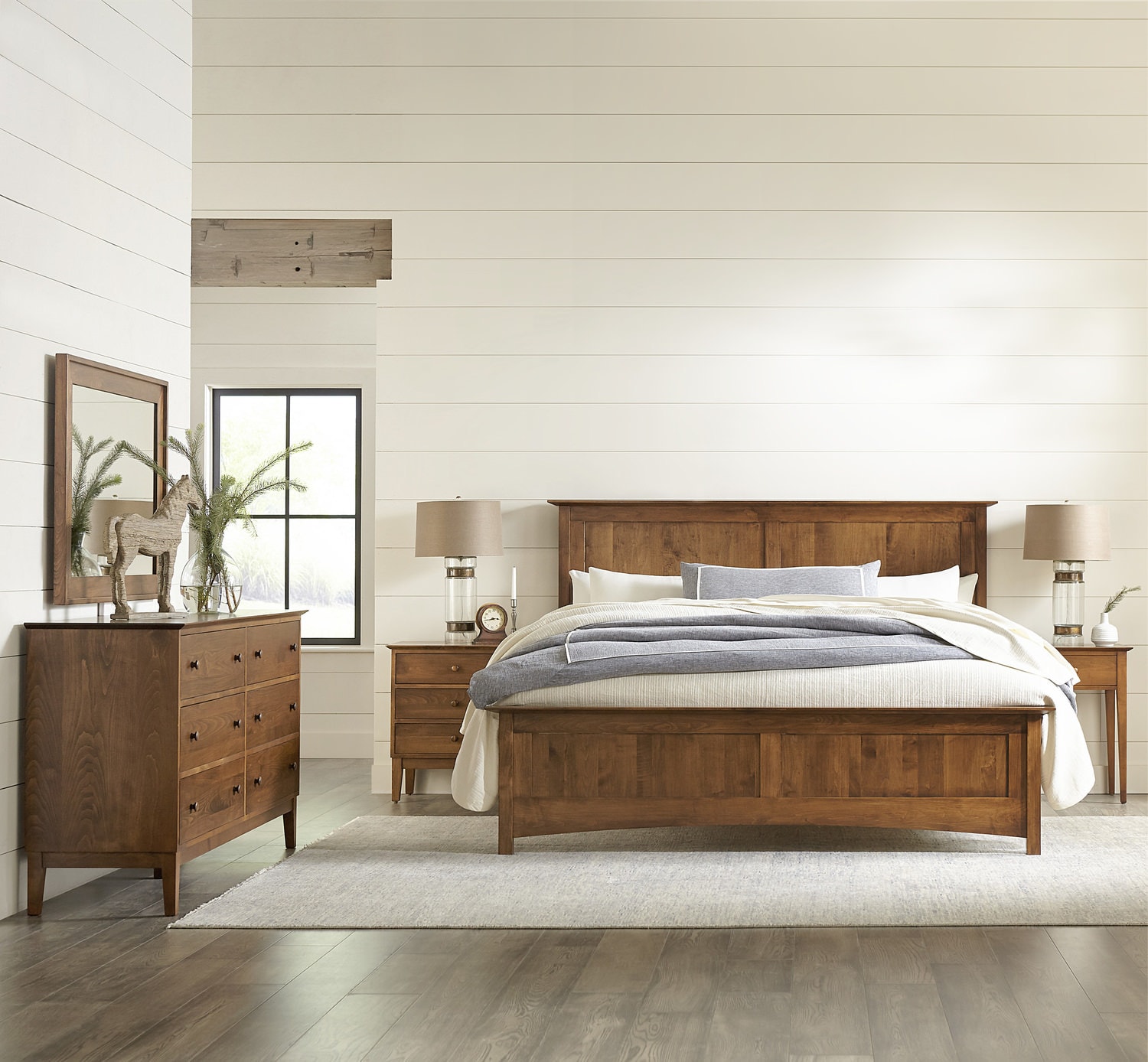 Modern bedroom with wooden furniture set including bed, dresser, and nightstands in a bright room