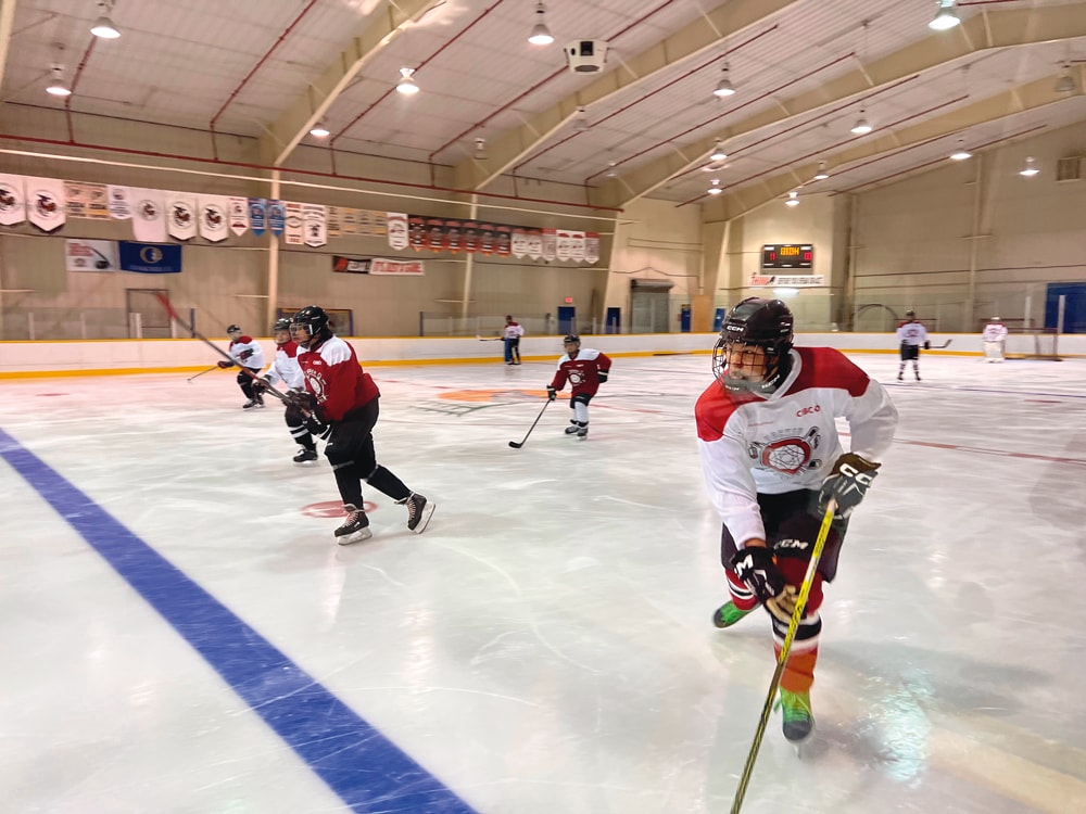 Jeunes jouant au hockey sur une patinoire intérieure
