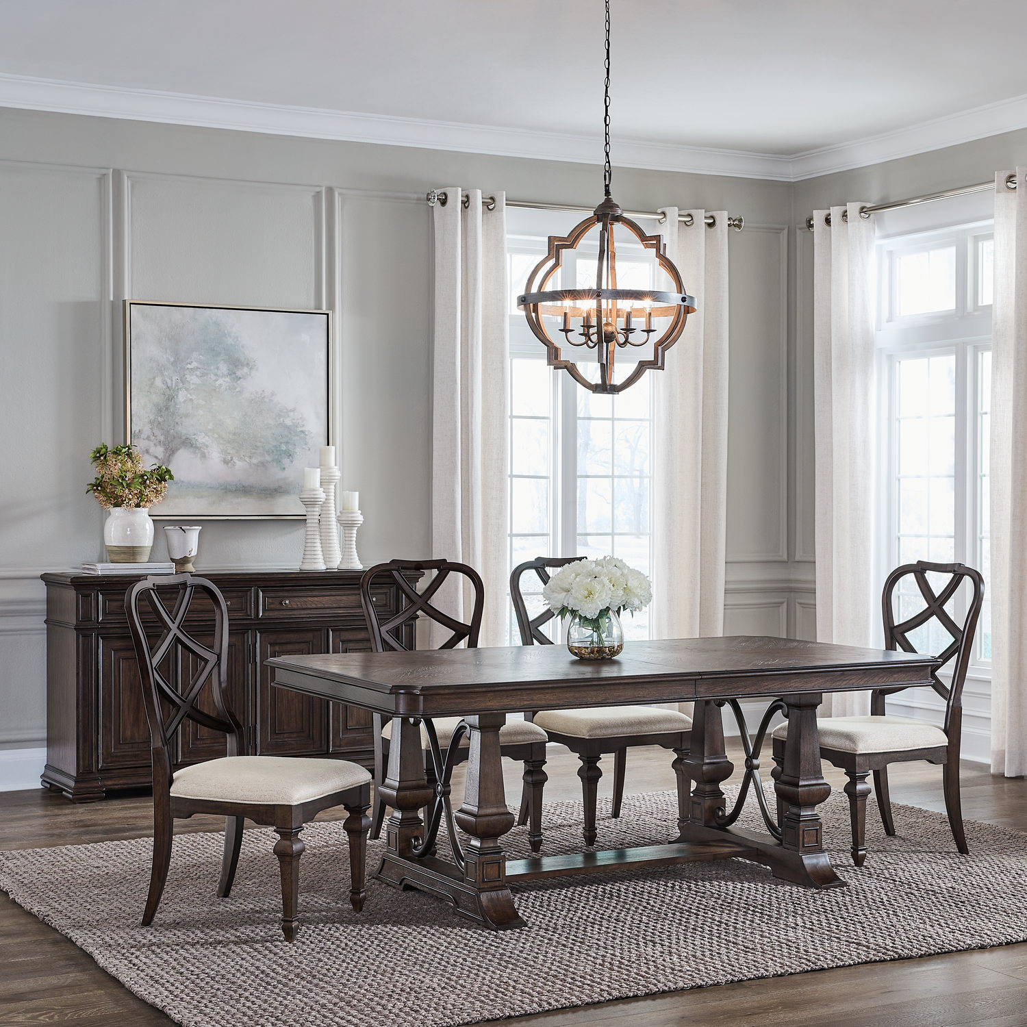 Elegant dining room with wooden table, chairs, and a chandelier, flanked by a buffet and subtle decor