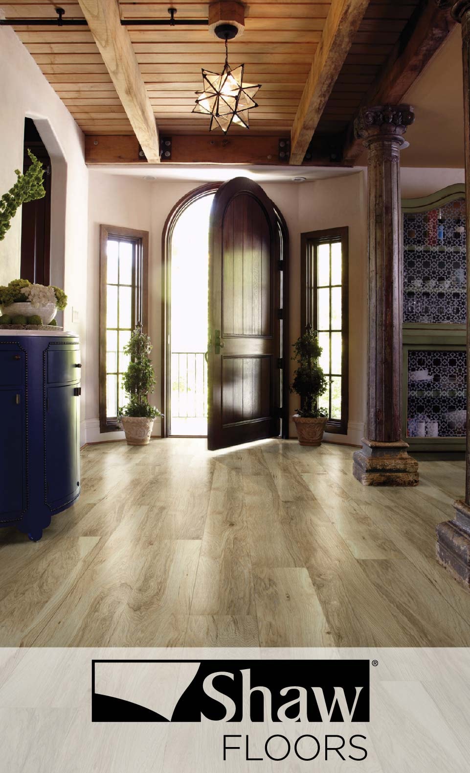 Interior of a luxurious entryway with arched double doors, elegant wood flooring by Shaw Floors, and decorative tiling