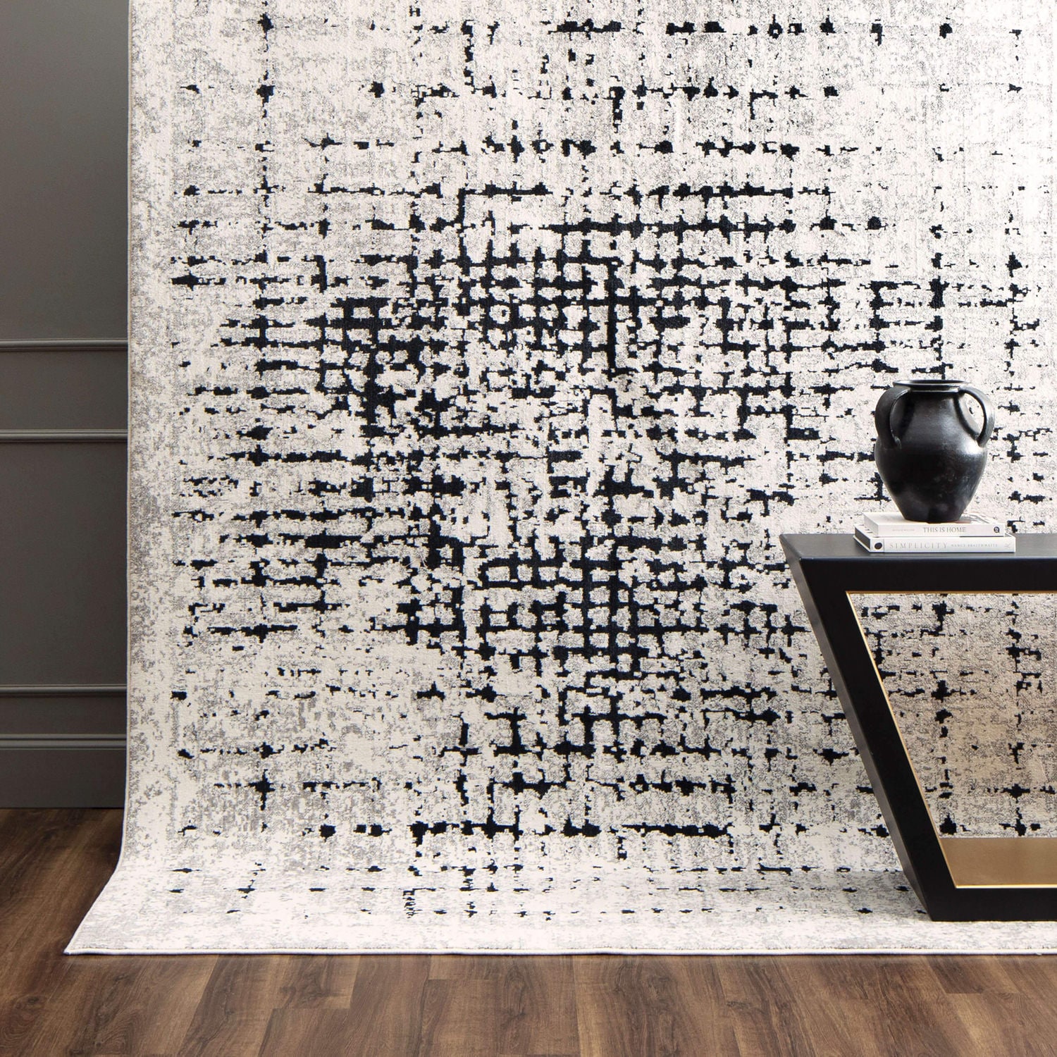 Modern black and white pixel pattern curtain in a room with a vase on a slim console table