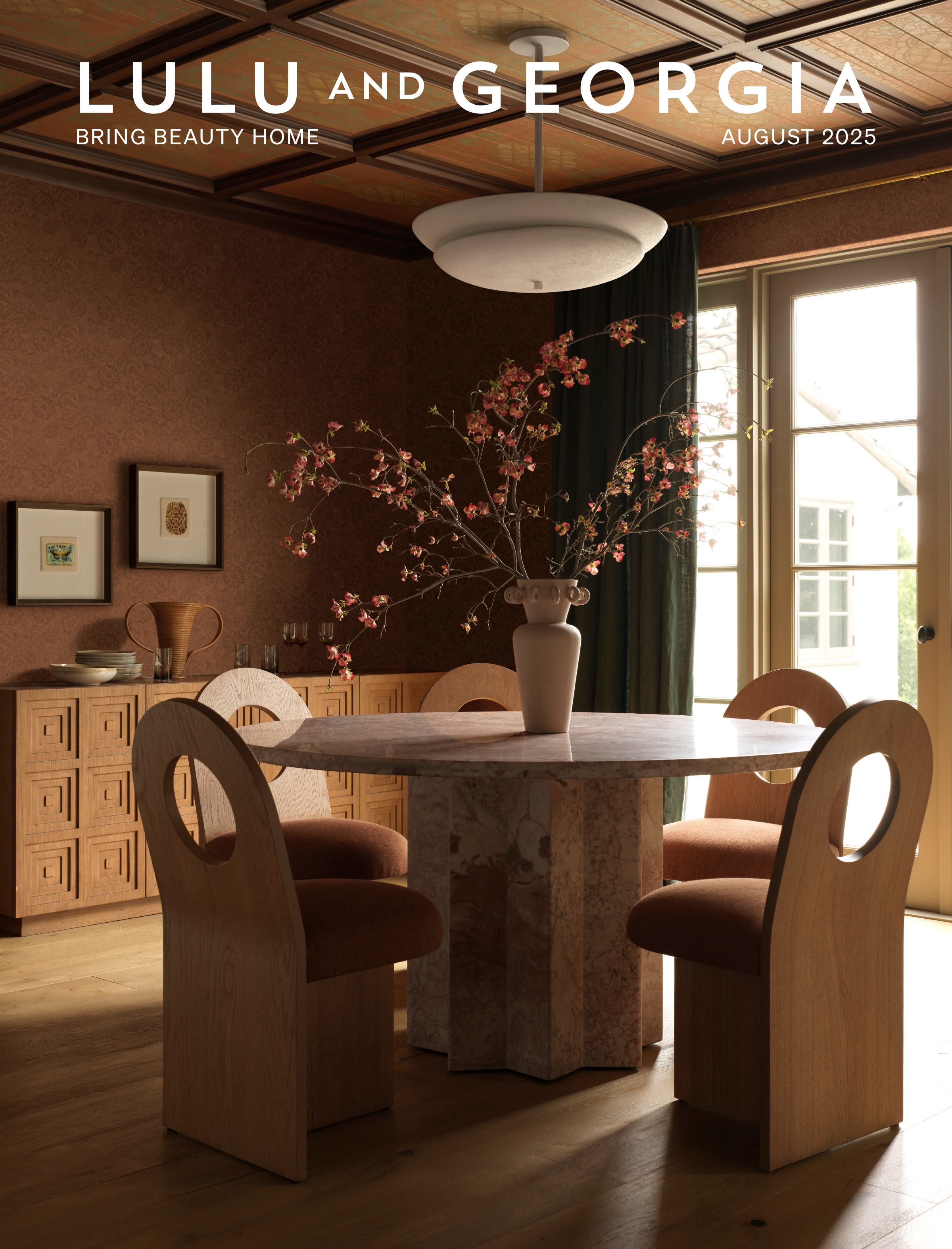 Magazine cover titled "Lulu and Georgia, August 2025," featuring a stylish dining room with modern table and chairs