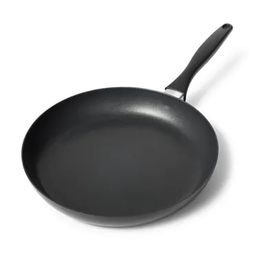 Non-stick frying pan with handle, used for cooking food on a stove