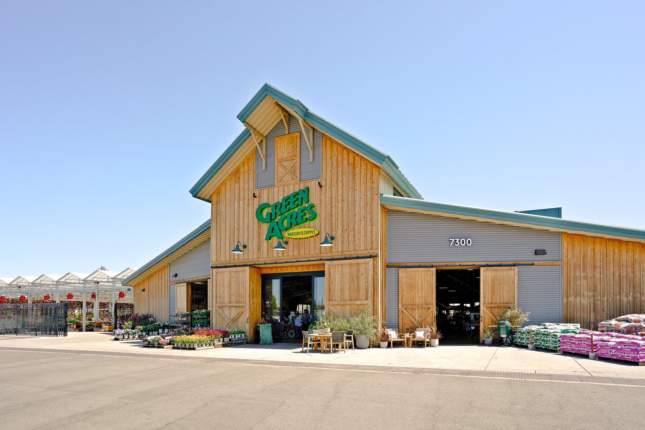 Exterior of a Cabela's store with a rustic wooden facade and displayed outdoor merchandise under a clear sky