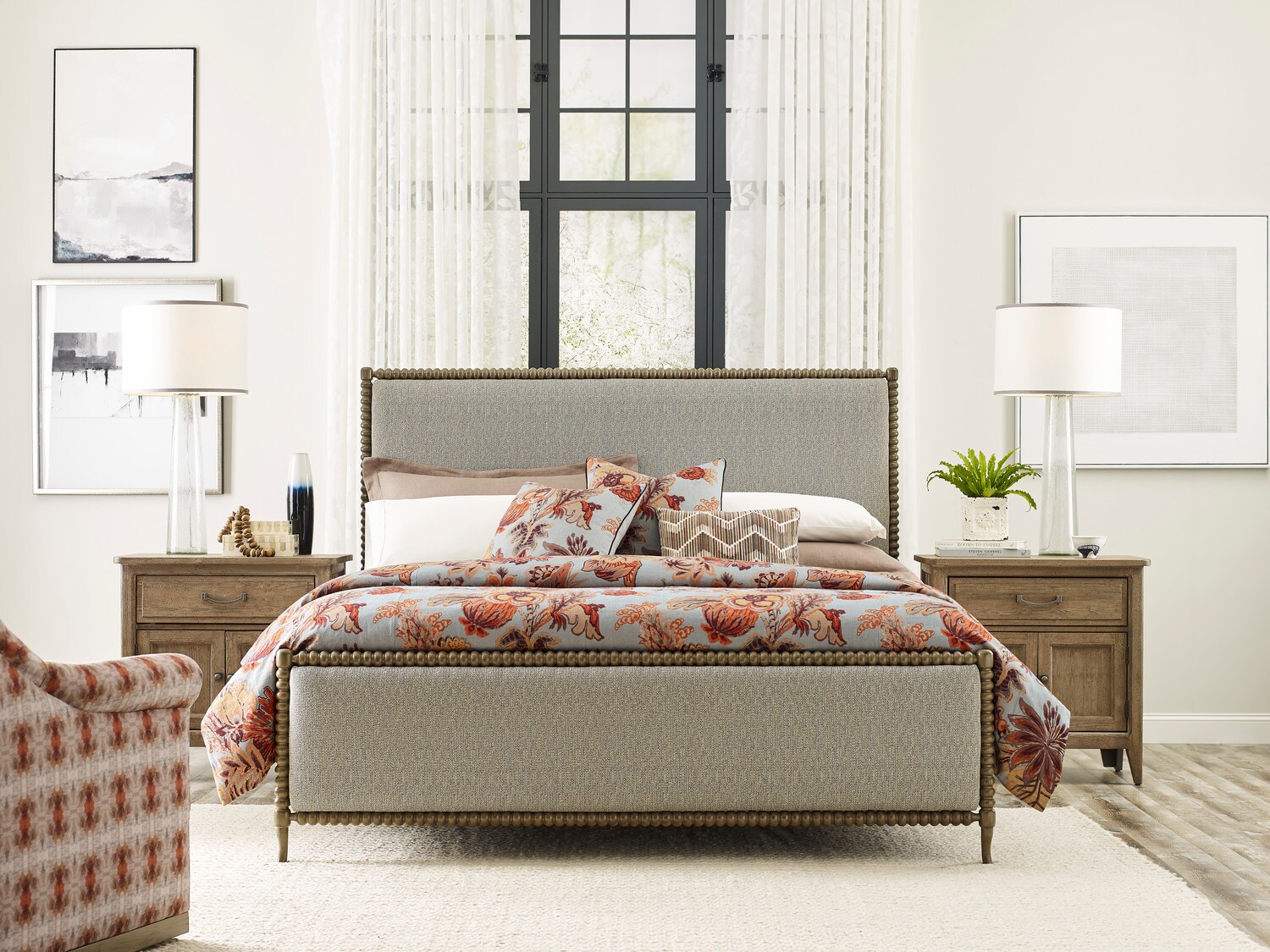 Elegant bedroom interior with a neatly made bed, matching wooden furniture, and bright window