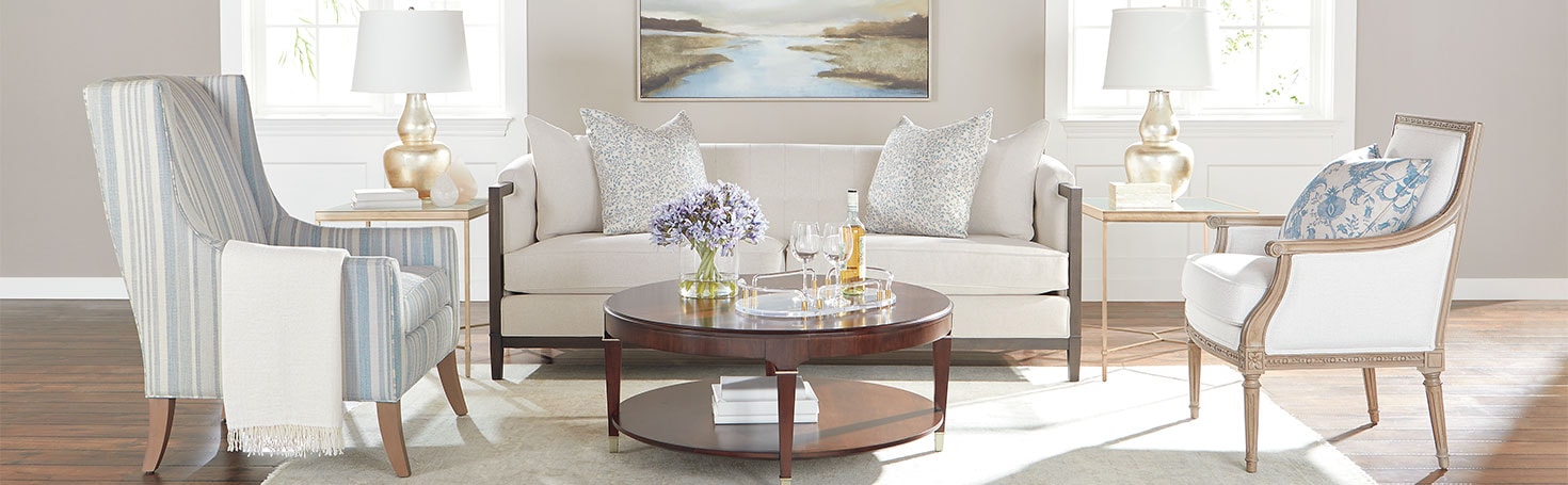Elegant living room with modern furniture, round coffee table, and decorative items in a bright setting