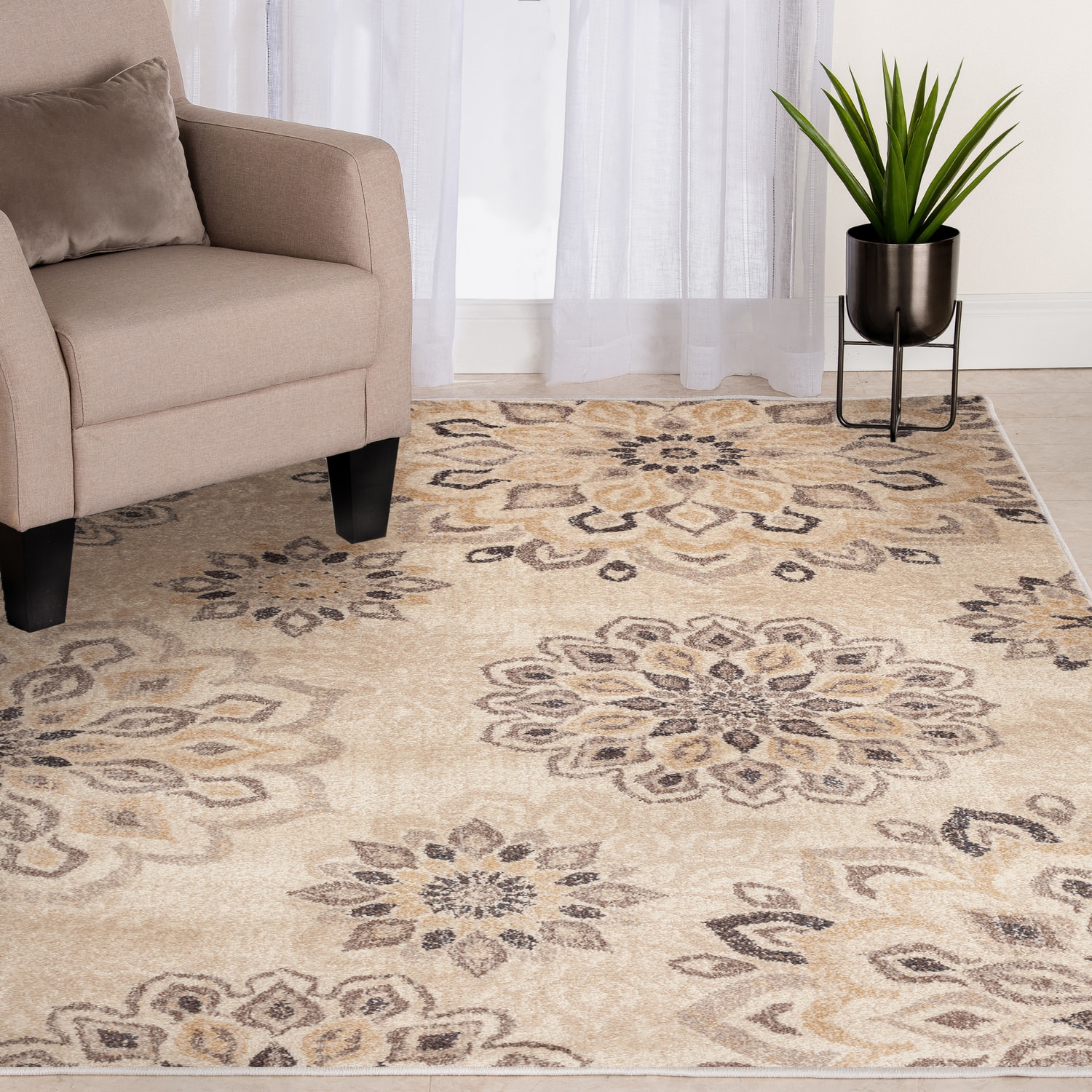 A patterned rug in a living room with a beige armchair and a plant on a dark stand