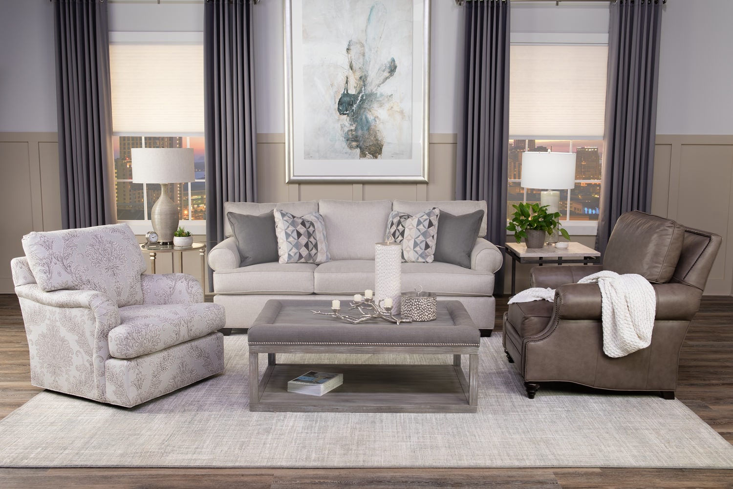 Elegant living room with neutral-toned sofa set, armchairs, and a centered coffee table under framed art