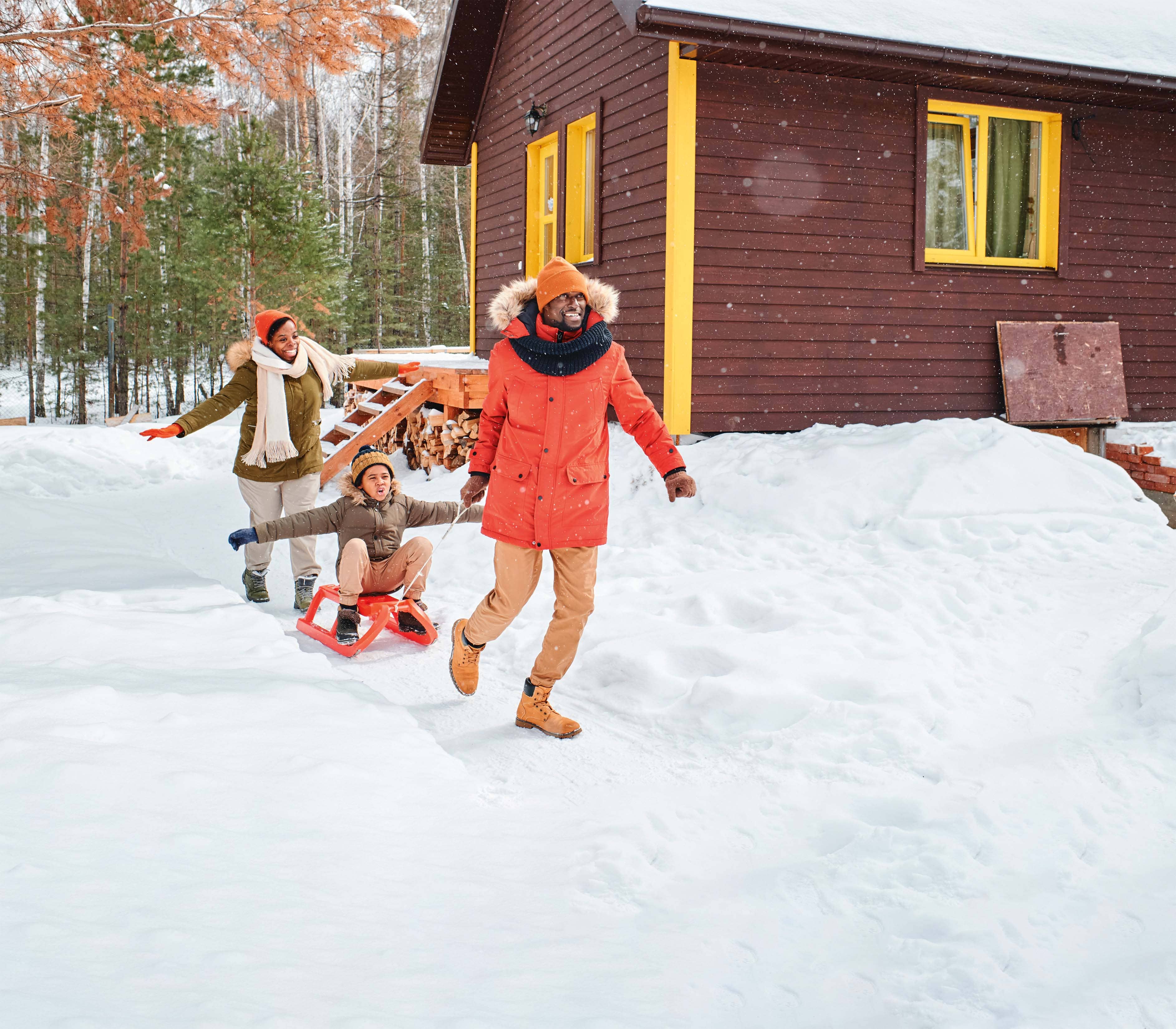 Famille jouant dans la neige devant une maison, non identifiée comme publicité