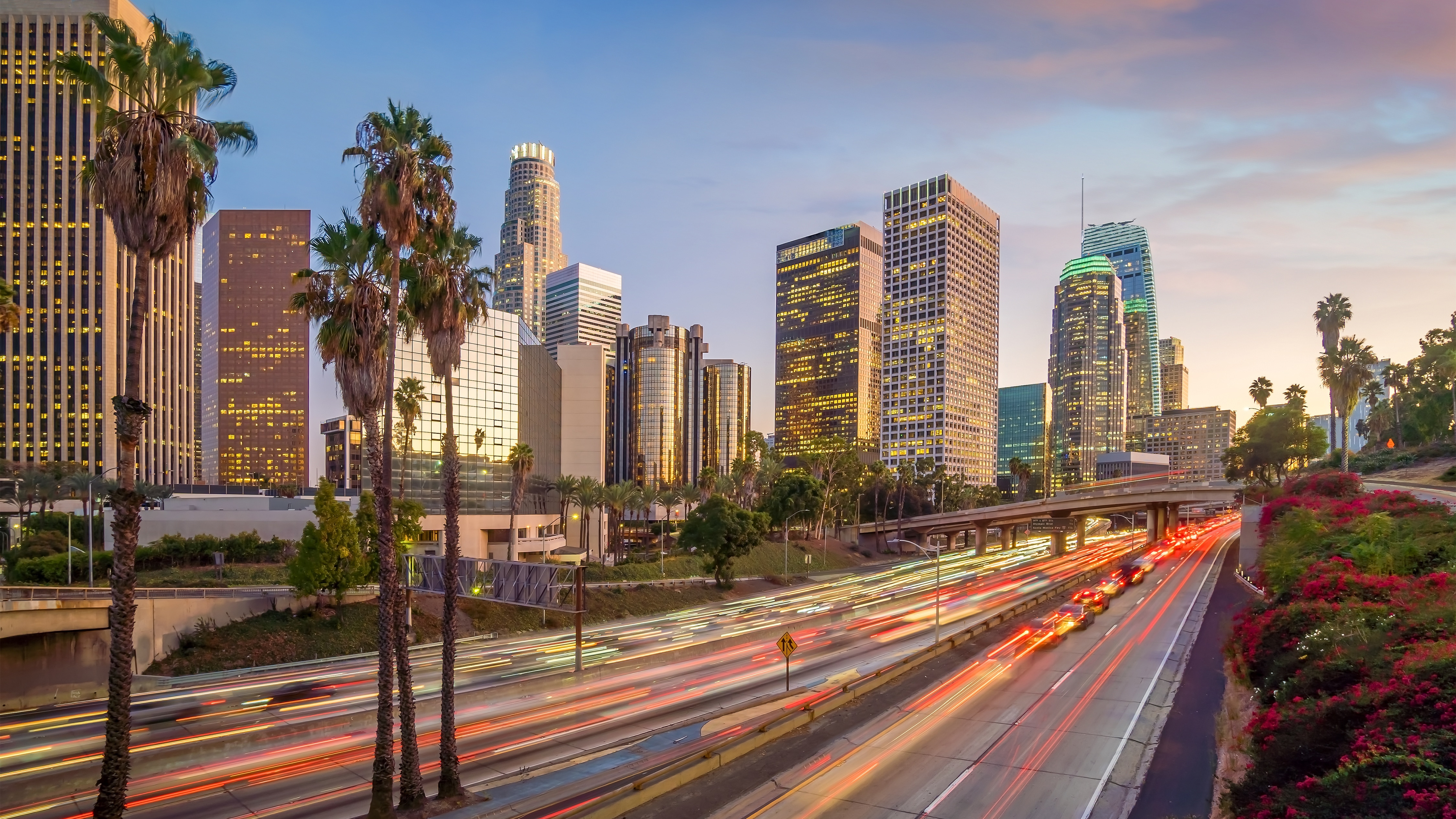 City skyline at sunset with tall buildings and busy street with light trails
