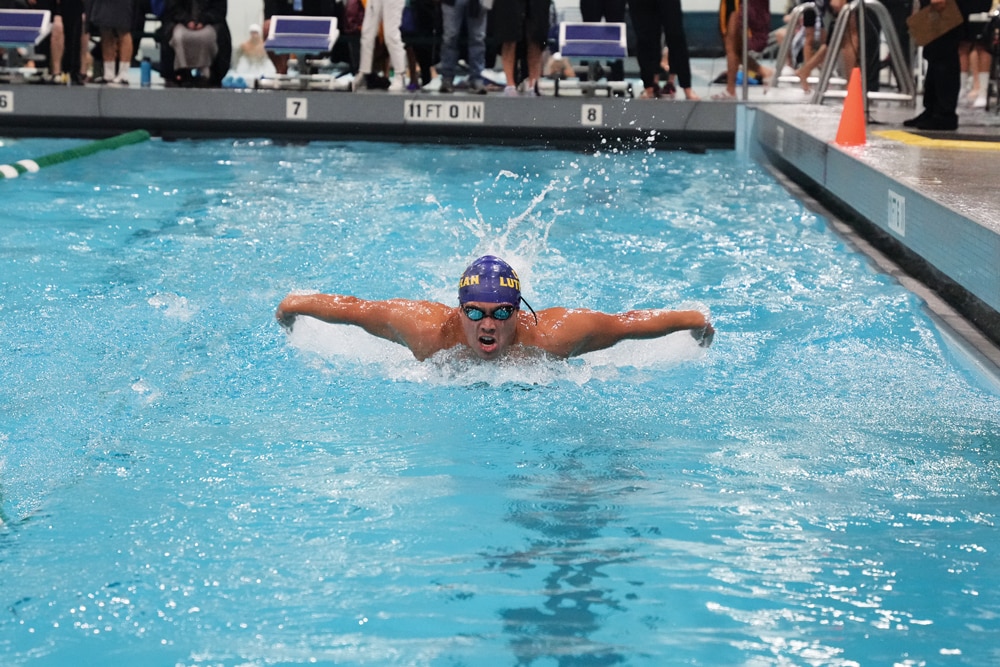 Nageur en compétition de papillon dans une piscine