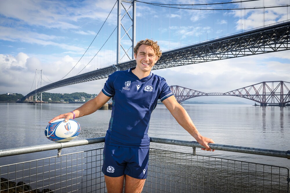 Joueur de rugby tenant un ballon devant un pont long