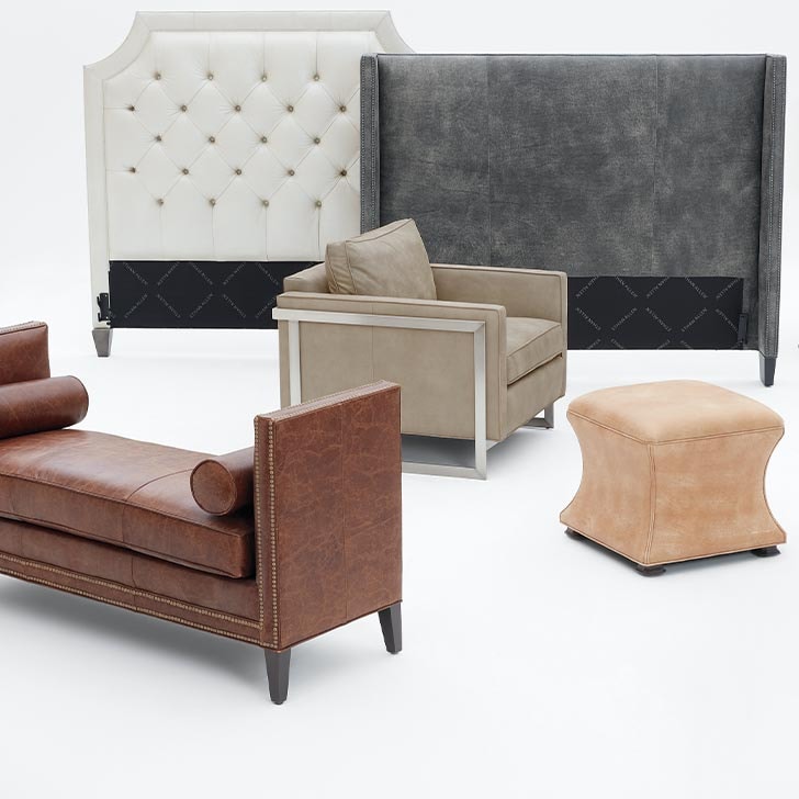 Variety of upholstered furniture including two beds, a couch, chair, and ottoman on a white background