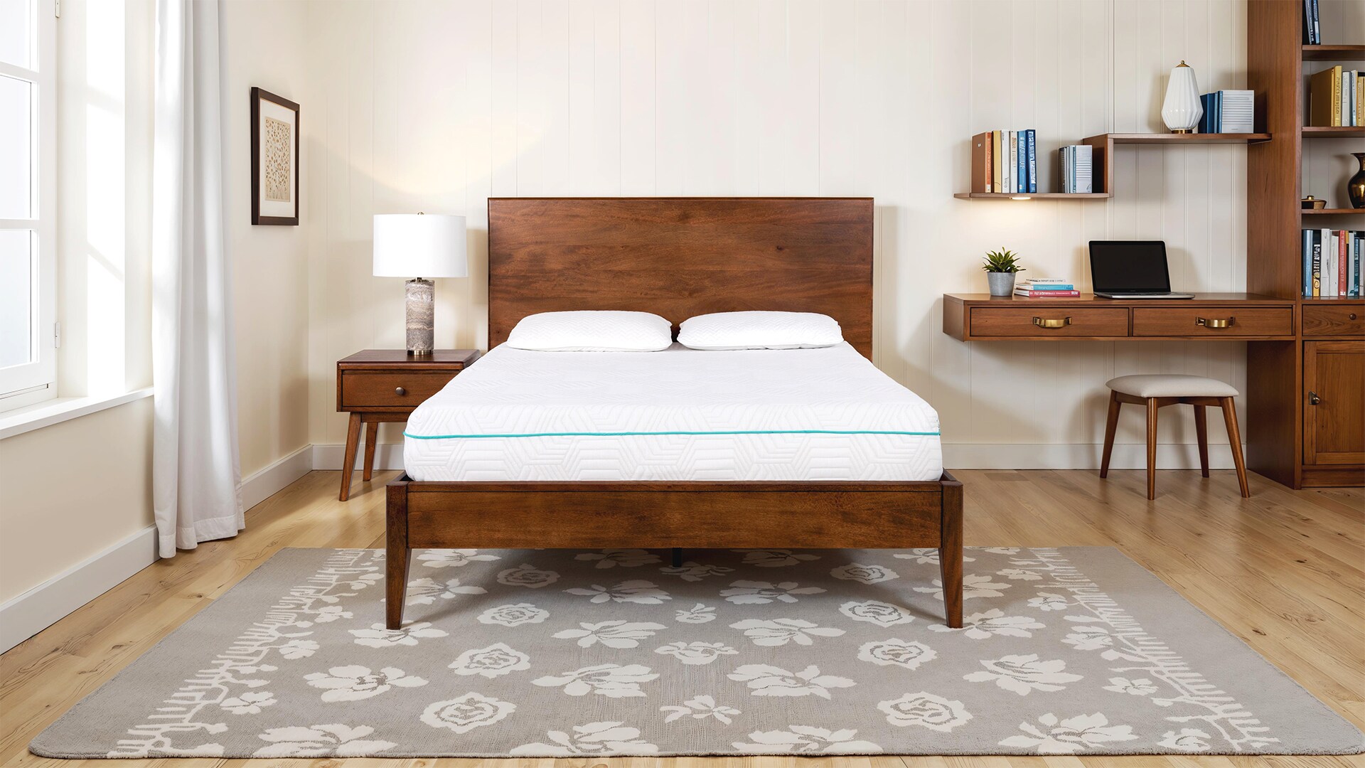 Minimalist bedroom with wooden bed, side table, desk, and patterned rug