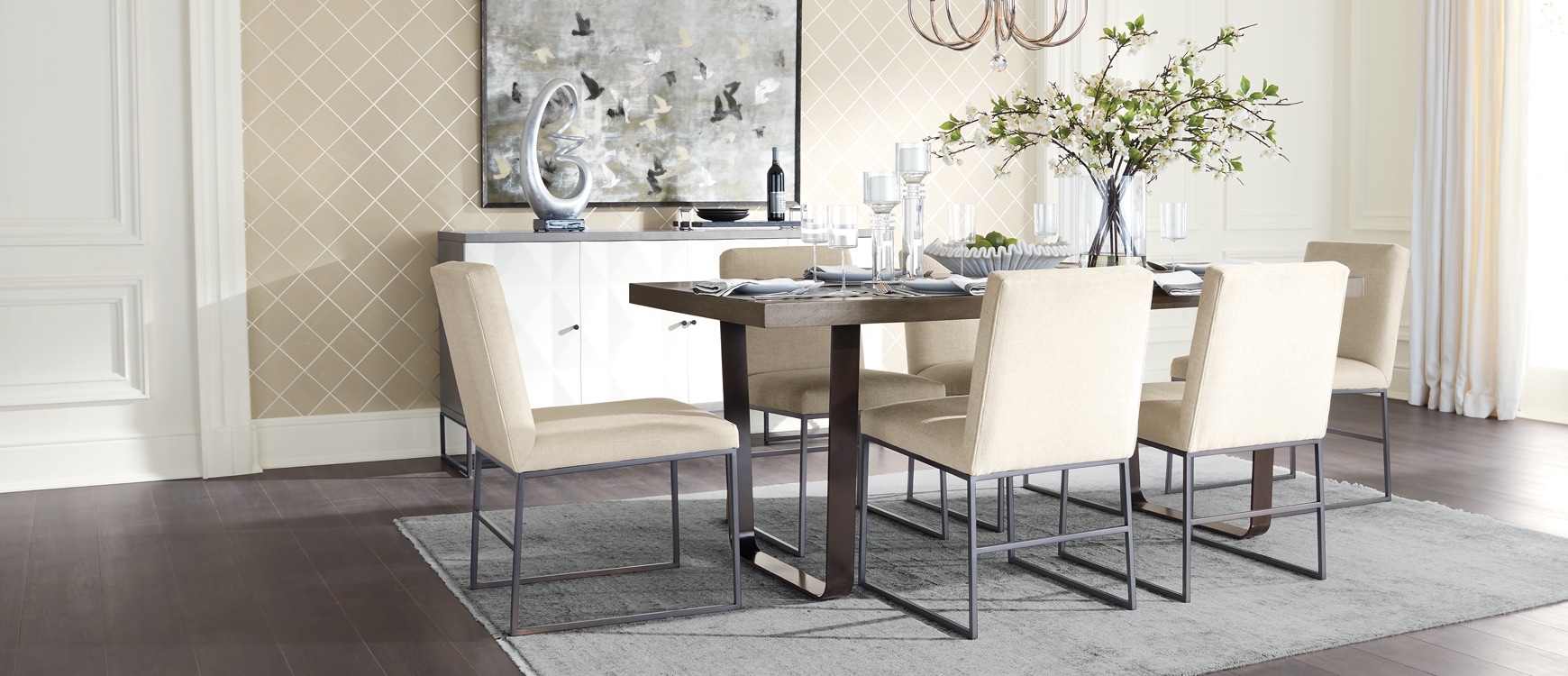 Elegant dining room with modern table, beige chairs, and decorative mirror