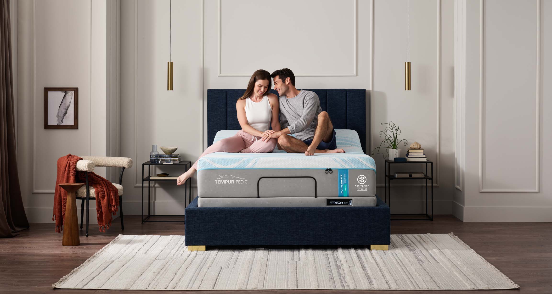 Couple sitting on a bed with an adjustable base in a well-decorated bedroom