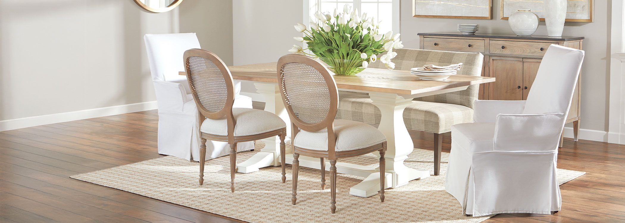 Bright dining room with a wooden table, white chairs, and natural light