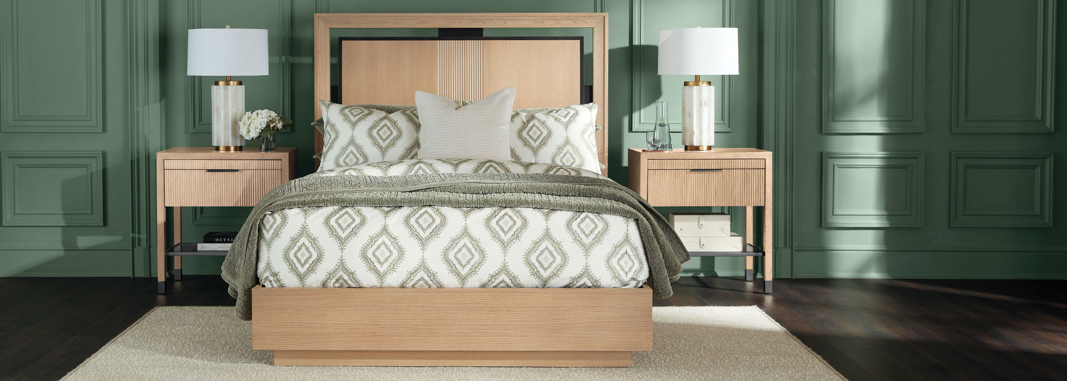 Elegant bedroom with patterned bed, wooden nightstands, and dark green walls