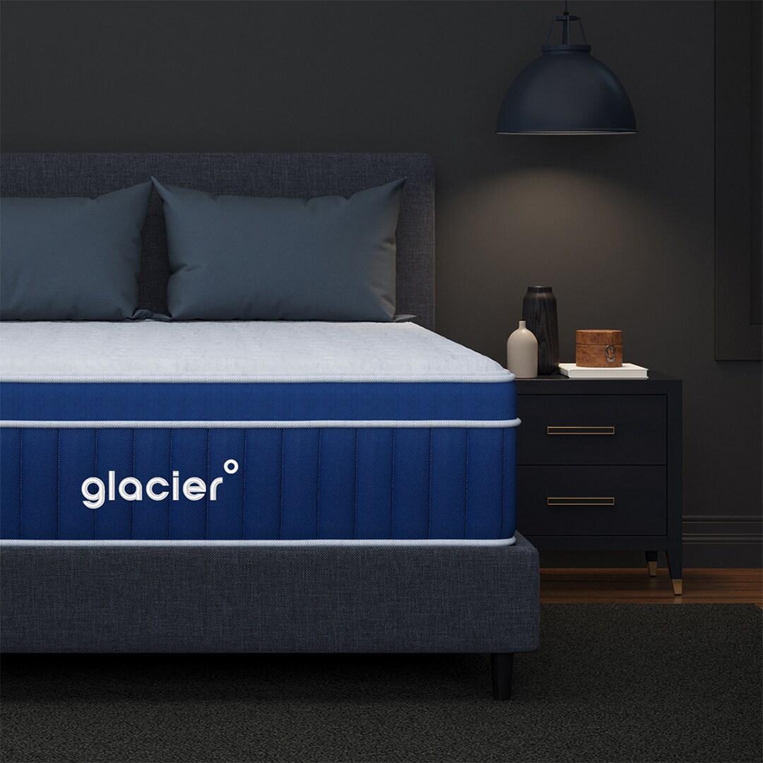 Modern bedroom with a blue Glacier-branded mattress and dark furnishings