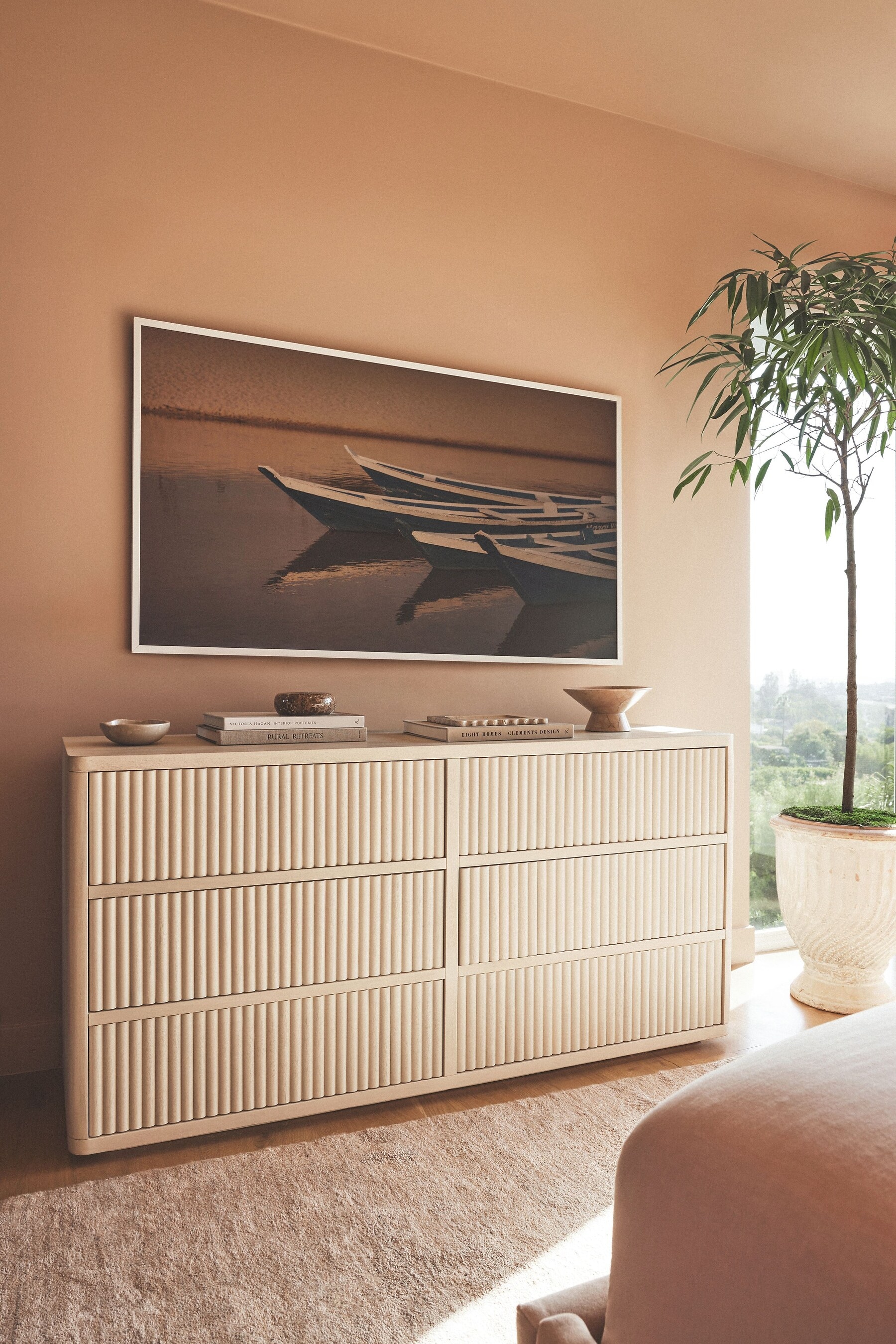 Modern living room with a cream-colored sideboard and framed abstract art on the wall