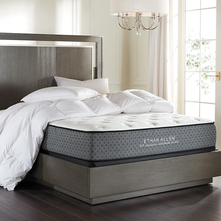 Luxury mattress in an elegant bedroom with white bedding and a chandelier