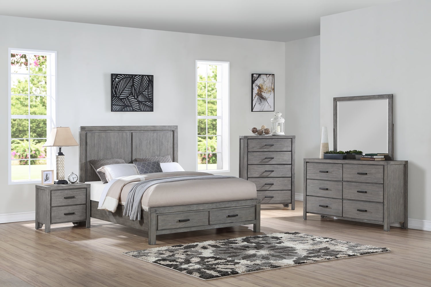 Modern bedroom with gray furniture set, including bed, dressers, and mirror, accented by a patterned rug