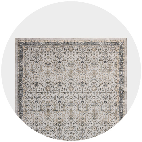A traditional beige and gray patterned rug displayed in a circular frame